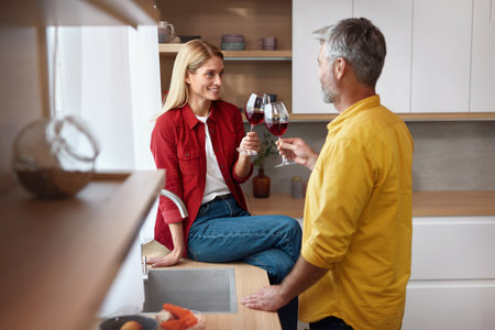 Happy Couple Drinking Wine. Smiling Senior Spouses Holding Wineglassesの写真素材