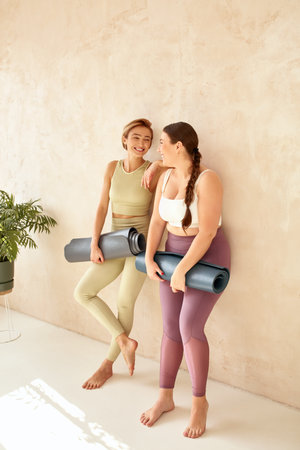 Women Embracing After Yoga. Female Friends Laughingの写真素材