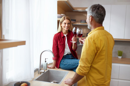 Happy Couple Drinking Wine. Smiling Senior Spouses Holding Wineglassesの写真素材