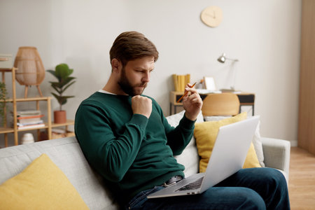 Focused Man Working Laptop. Handsome Young Man Using Laptop Computerの写真素材