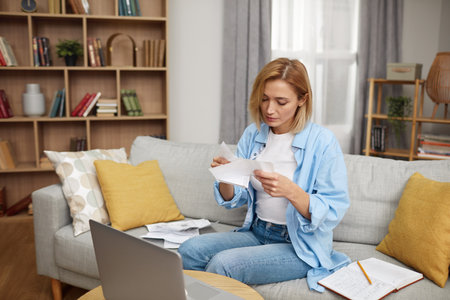 Serious Woman Paying Bills. Worried Lady Calculating And Paying Billsの写真素材