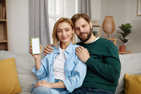 Couple Showing Mobile Display. Portrait of Happy Couple Holding Smartphoneの写真素材
