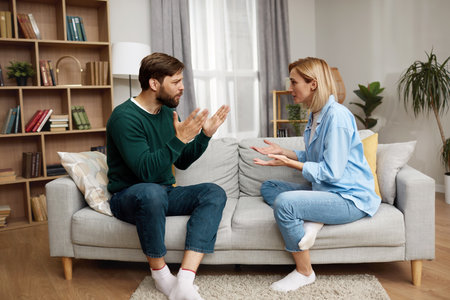 Couple Having Argument At Home. Angry Wife Shouting At Husband Of Problemの写真素材