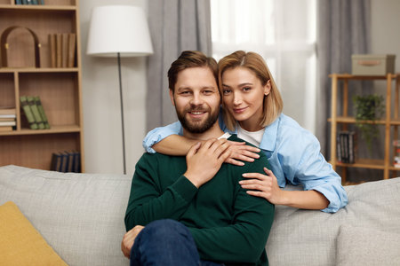Romantic Couple Embracing Sofa. Happy Couple Relaxing On Couch At Homeの写真素材
