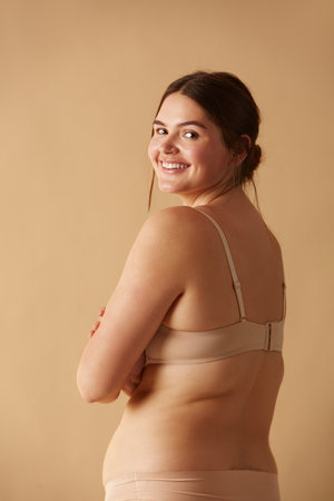 Full Figured Woman. Happy Curvy Oversize Woman Posing In Beige Lingerieの写真素材