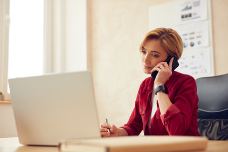 Serious Businesswoman Calling Smartphone. Positive Blonde Woman Talking On Phoneの写真素材
