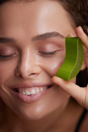 Aloe Woman. Girl Holding Slices Of Fresh Juicy Aloe Vera Leaf Near Her Faceの写真素材