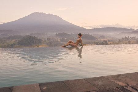 Woman Enjoying Luxury Resort Pool View of Bali Volcano Agungの写真素材