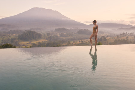 Luxury Resort. Woman Relaxing In Swimming Pool Water at Mountainsの写真素材