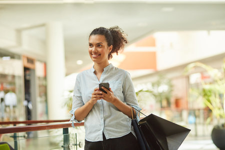 Happy Woman Smiling, Using Smartphone for Shopping Spreeの写真素材