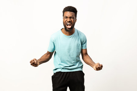 Energetic Man Celebrating Success on Plain Backgroundの写真素材