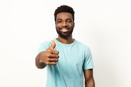 Smiling Man Giving Thumbs up Gesture in Casual Attireの写真素材