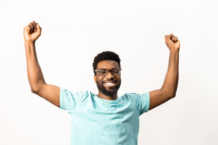 Cheerful African American Man Celebrating Success Isolated on Whiteの写真素材