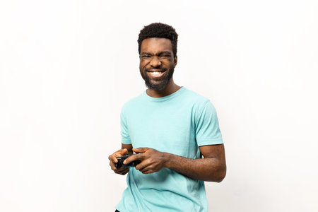 Happy African American Man Playing Video Games Isolated on Whiteの写真素材