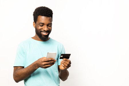 Afro American Man Using Smartphone and Credit Cardの写真素材
