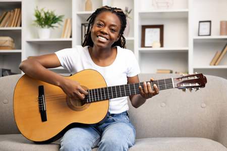 Woman Enjoying Music, Playing Guitar at Homeの写真素材