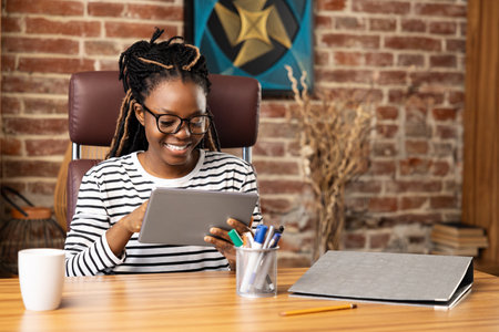 Happy Afro American Woman Using Tablet for Video Call at Homeの写真素材