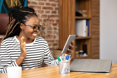 Happy Afro American Woman Enjoying Video Call at Home Officeの写真素材