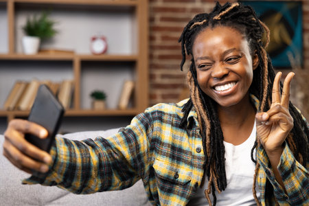 Smiling Afro American Woman Enjoying Video Call at Homeの写真素材