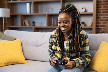 Smiling Afro American Woman Enjoying Video Games at Homeの写真素材