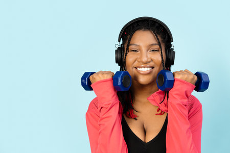 Woman Exercising with Dumbbells and Headphonesの写真素材