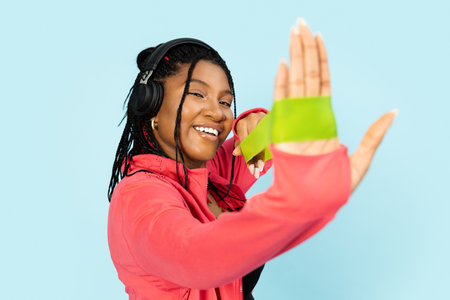 Woman Stretching Fitness Rubber Band and Enjoying Music with Headphonesの写真素材