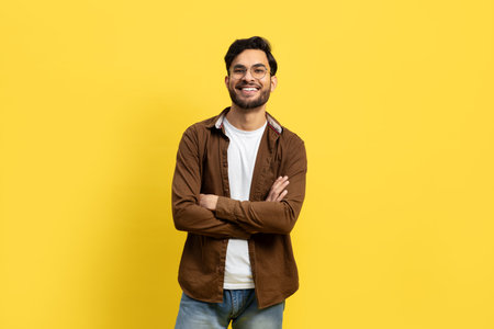 Confident Young Man in Casual Wear Against Yellow Backgroundの写真素材