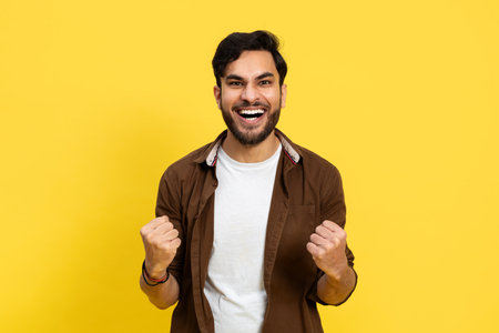 Happy Man Celebrating Success On Yellow Backgroundの写真素材