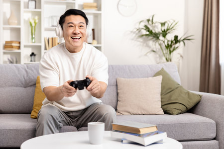 Happy Man Playing Video Games on Couch at Homeの写真素材