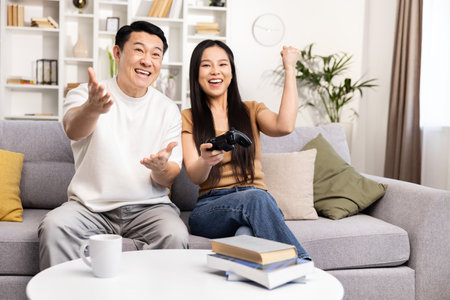 Joyful Couple Playing Video Games on the Couch Togetherの写真素材
