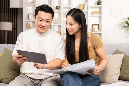 Couple Planning Budget with Tablet and Documents at Homeの写真素材