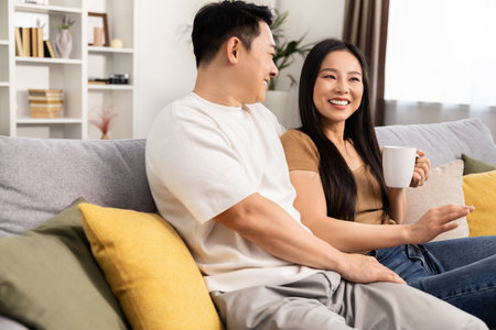 Happy Couple Enjoying Coffee and Conversation at Homeの写真素材