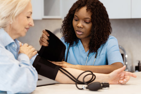 Healthcare Professional Checking Blood Pressure of Senior Patient in Clinicの写真素材