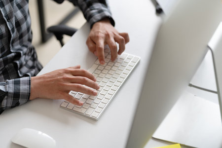 Person Typing on Keyboard in Office Environmentの写真素材