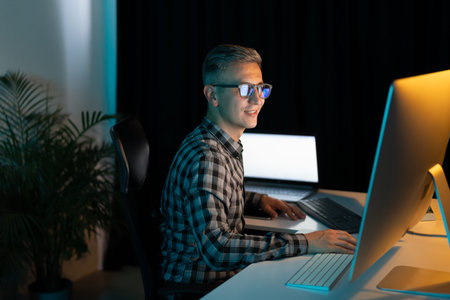 Focused Man Working on Computer Late at Night in Office