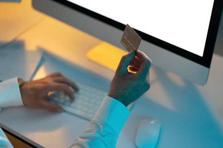 Person Hand Holding Credit Card Shopping Online on Computerの写真素材
