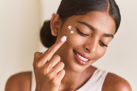 Face Skincare. Woman Applying Face Cream Skincare With Joyful Expressionの写真素材