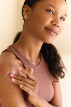 Woman Moisturizing Skin with Cream for Healthy and Glowing Appearanceの写真素材