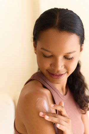 Woman Applying Moisturizing Lotion on Shoulder for Smooth and Radiant Skinの写真素材