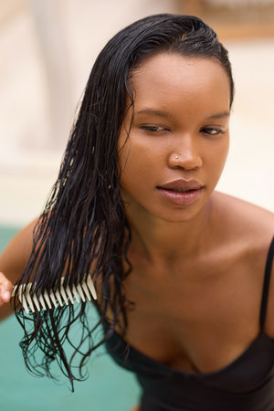 Woman Combing Wet Hair With Focus on Natural Hair Care Routineの写真素材