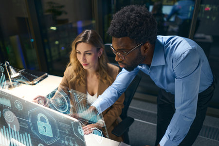 Team Collaborating on Cybersecurity Solutions Using Innovative Technology Displays in Modern Workspaceの写真素材