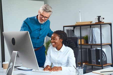 Office Team Collaboration With Smiling Professionals Working Together at a Computer Desk