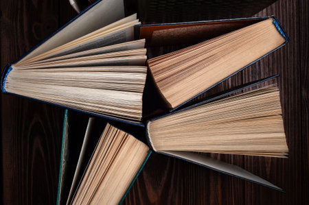 Old books. Close-up group of old used open books on a dark background. Books textbooks for reading...
