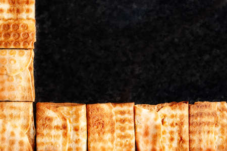 Top view frame of crispy cookies stacked on black marble. Freshly baked cookies. Selective soft focus with copy space.の写真素材