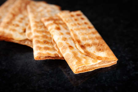 Three fried crispy cookies stacked on a black background. Freshly baked cookies. Selective soft focus.の写真素材