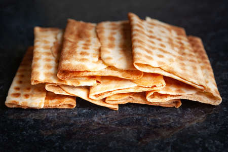 Ruddy dry crispy biscuits stacked on black marble. Freshly baked cookies. Selective soft focus.の写真素材
