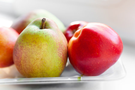 Close-up autumn fruits on a plate. Pears and apples are stacked in a plate. Selective soft focus....