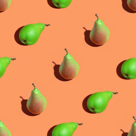 Fruit seamless pattern of fresh juicy pears on an orange background. Ripe organic pears isolated on an orange surface. Vegan, vegetarian healthy food. Diet organic product.の写真素材