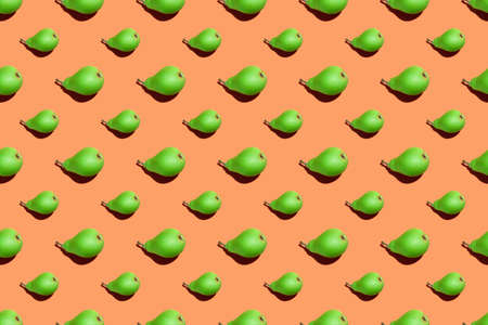 Juicy green pears pattern. Colorful seamless pattern of fresh pears on an orange background. Fresh ripe organic pears isolated on orange surface. Vegan, vegetarian healthy food. Diet organic product.の写真素材
