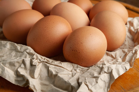 Brown eggs. Raw brown chicken eggs on crumpled wrapping paper. High calorie protein food concept....